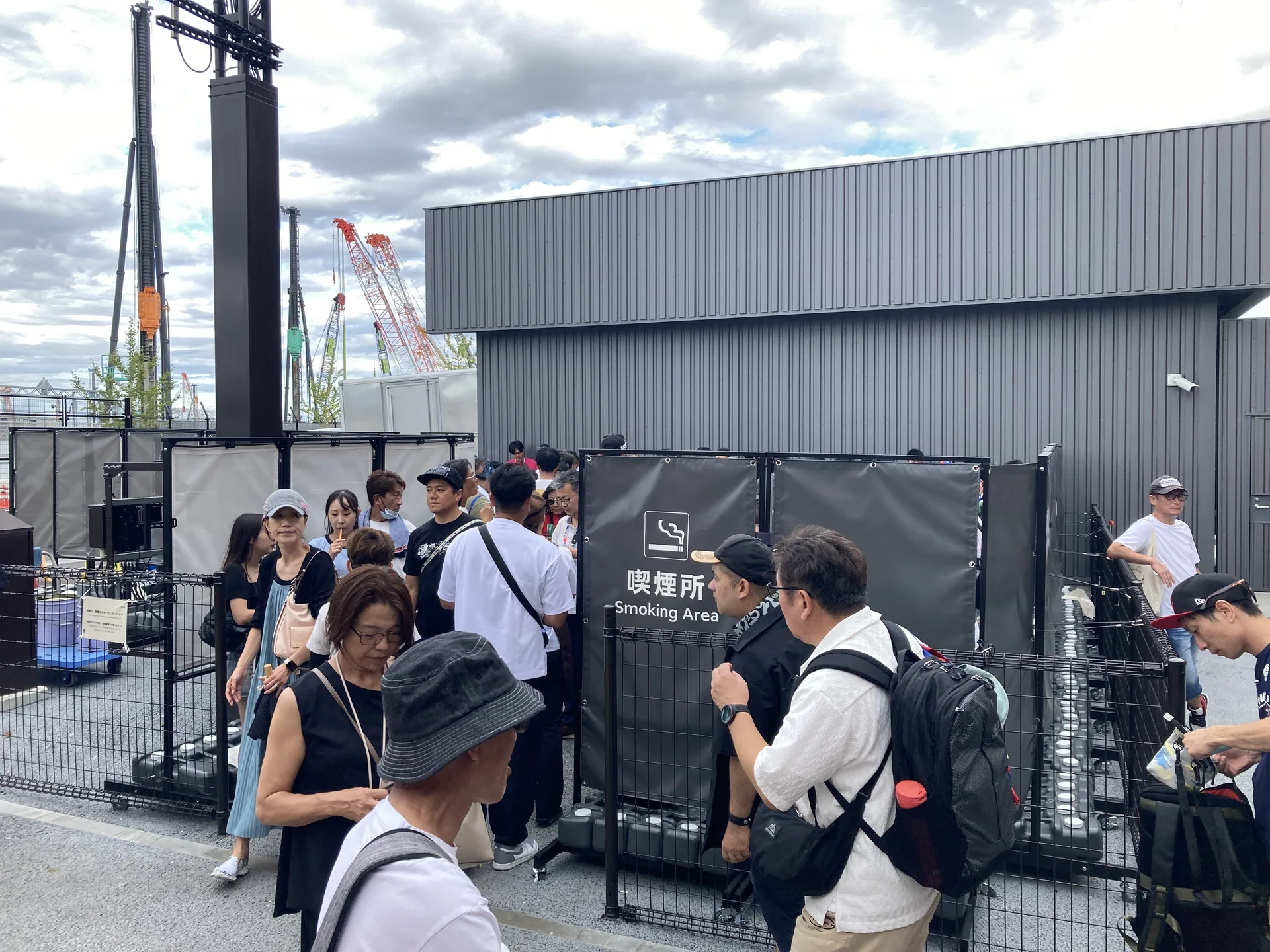場外の喫煙所に集まる来場者たち